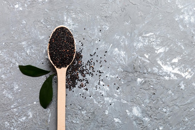 Sementes de quinoa em colher sobre fundo colorido Kinwa saudável em colher pequena Superalimento saudável