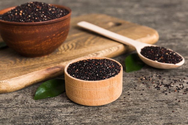 Sementes de quinoa em tigela e colher em fundo colorido Kinwa saudável em tigela pequena Superalimento saudável