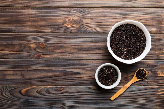 Sementes de quinoa em tigela e colher em fundo colorido Kinwa saudável em tigela pequena Superalimento saudável