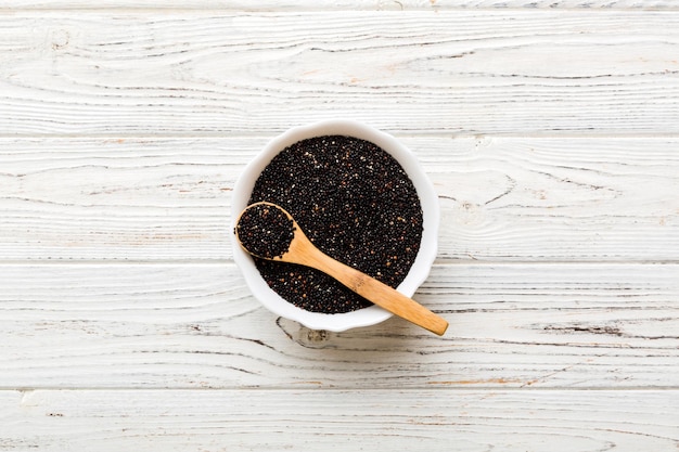 sementes de quinoa em tigela e colher em fundo colorido Kinwa saudável em tigela pequena Superalimento saudável