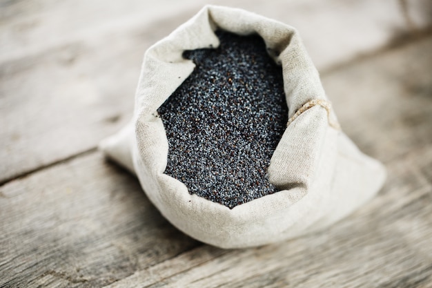 Semillas de amapola en una bolsa de arpillera. Las sabrosas y útiles semillas ricas en proteínas y aceites.