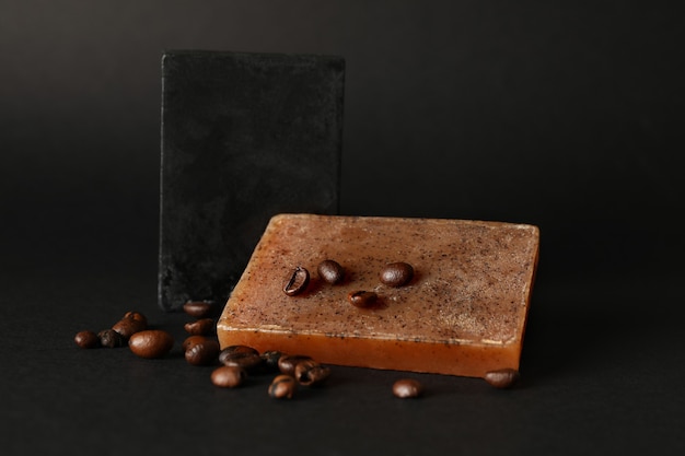 Semillas de café y jabón natural sobre superficie negra