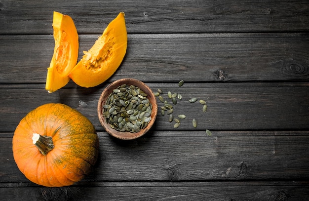 Foto semillas de calabaza en un bol y trozos de calabaza madura