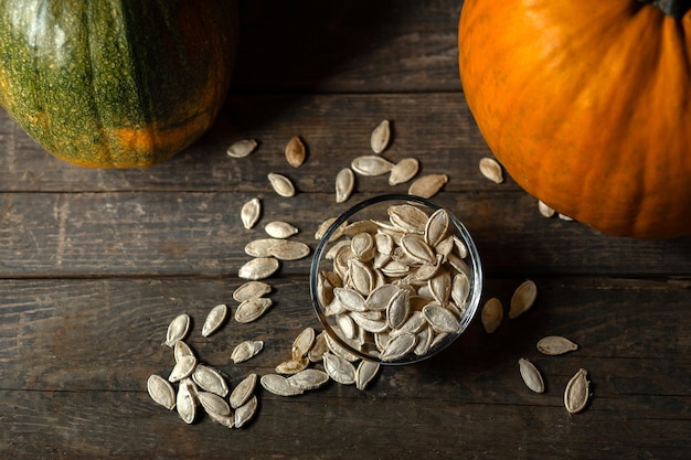 Semillas de calabaza en un platillo de vidrio sobre un fondo de madera