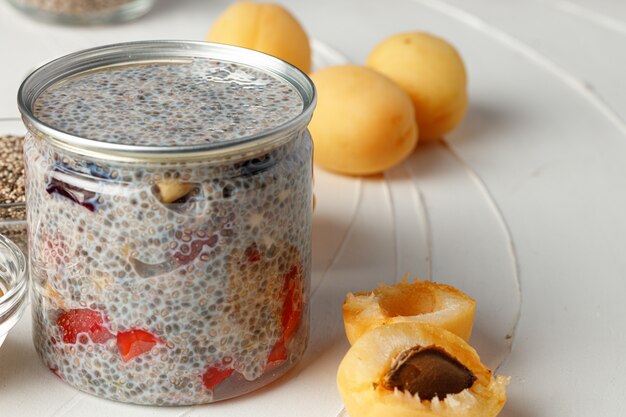 Semillas de chía con bayas y nueces en mesa blanca