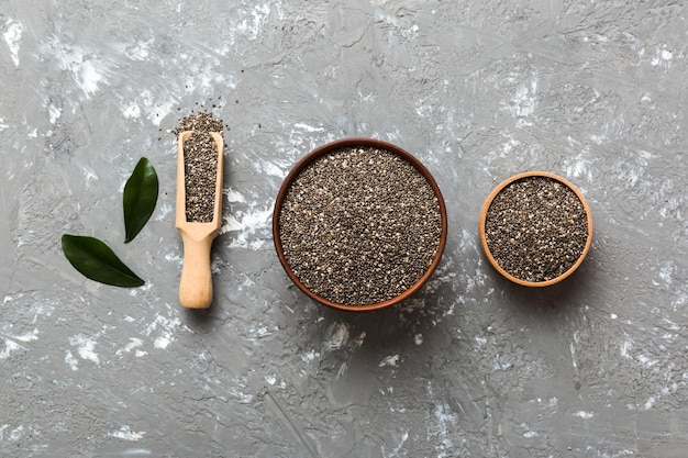 Semillas de chía en un tazón y una cuchara sobre fondo de color Saludable Salvia hispanica en un tazón pequeño Superalimento saludable