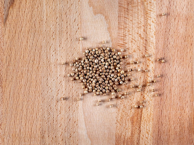 Semillas de cilantro sobre una superficie de madera. primer plano, vista superior