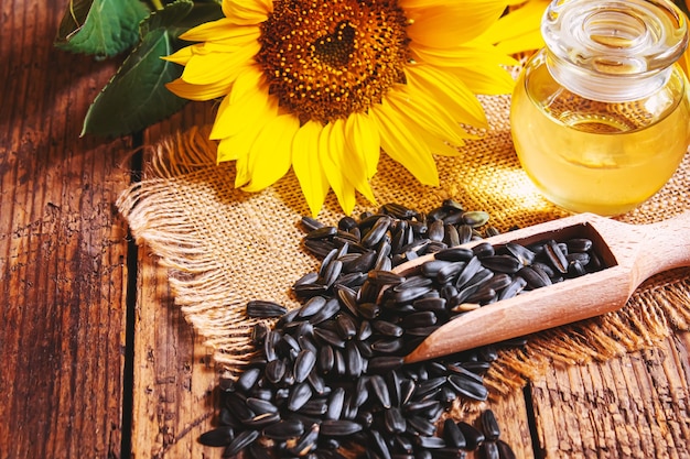 Semillas de girasol y botella de aceite sobre fondo de madera vieja. Enfoque selectivo naturaleza