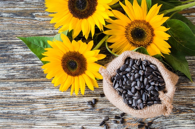 Semillas de girasol crudas en bolsa de arpillera sobre una mesa de madera