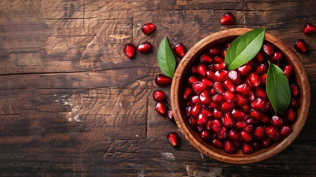 Semillas de granada frescas y maduras en un cuenco sobre un fondo rústico de madera frutas rojas saludables concepto de copia de espacio