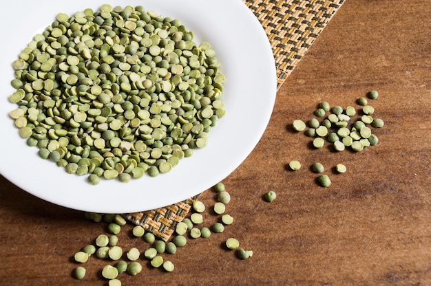 Semillas de guisantes crudas en el plato y la mesa