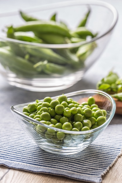 Semillas de guisantes verdes frescas en un recipiente sobre la mesa de la cocina.