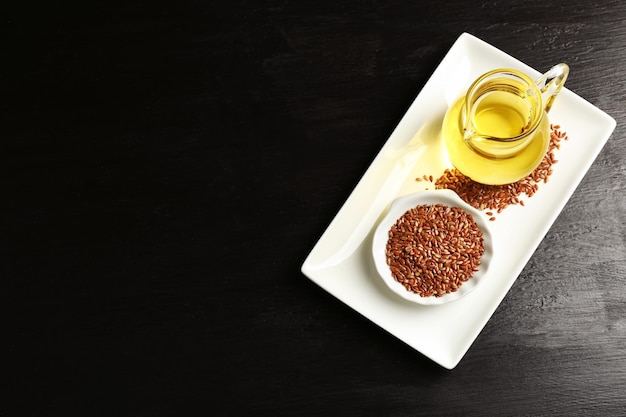 Semillas de lino con aceite en mesa de madera