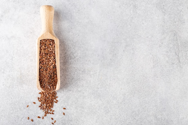 Foto semillas de lino en una cuchara de madera para productos a granel