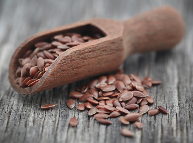 Semillas de lino en una cuchara de madera sobre superficie natural