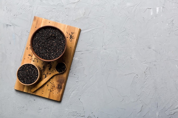 Semillas de quinua en un tazón y cuchara sobre fondo de color Kinwa saludable en un tazón pequeño Superalimento saludable