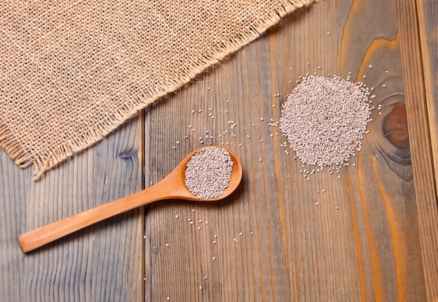 Semillas sanas de Chia en cuchara de madera en la tabla de madera. Vista superior.