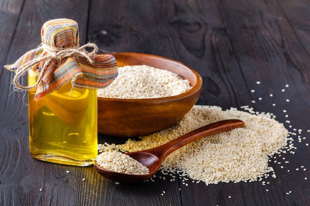 Semillas de sésamo y aceite en la mesa de madera