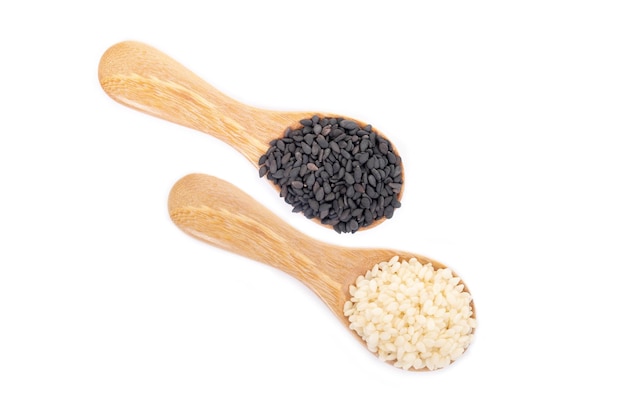Semillas de sésamo negro y semillas de sésamo blanco orgánico en cuchara de madera sobre fondo blanco. Concepto de comida sana.