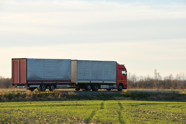 Semirremolque con remolque de carga conduciendo por carretera transportando mercancías por la noche. Concepto de logística y transporte de entrega.