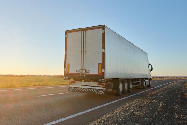 Semirremolque con remolque de carga conduciendo por carretera transportando mercancías por la noche. Concepto de transporte y logística de entrega.