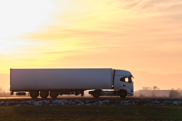 Semitruck com reboque de carga dirigindo na rodovia transportando mercadorias à noite Conceito de transporte e logística de entrega