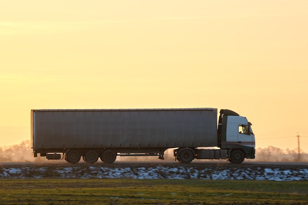 Semitruck com reboque de carga dirigindo na rodovia transportando mercadorias à noite Conceito de transporte e logística de entrega