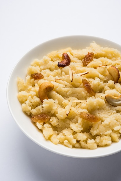 Semolina ou Soji Halwa com sabor a açafrão ou simples, também conhecido como Sweet Rava Sheera OU Shira - doce festivo indiano decorado com frutas secas. Servido em um prato ou tigela, foco seletivo