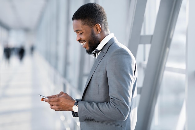 Sempre em contato empresário mandando mensagens no telefone esperando o voo