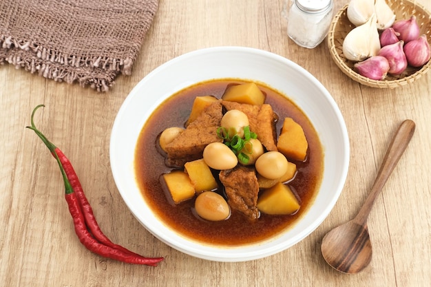 Semur, indonesisches traditionelles Essen, mit Tofu, Wachteleiern und Kartoffeln, serviert in einer Schüssel.