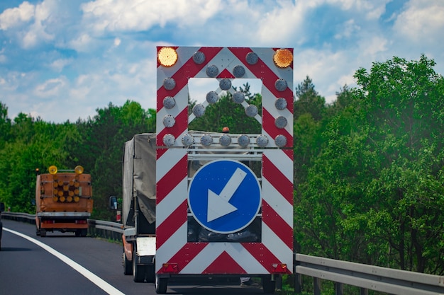 Una señal de advertencia en la carretera corre más adelante. Señal de tráfico. Reparación de carreteras.