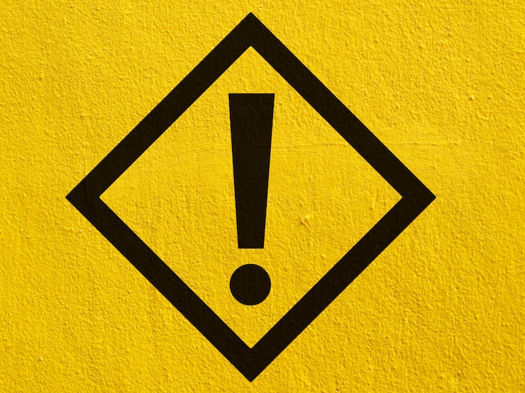 Foto una señal de atención de advertencia negra señala un punto pintado en una pared de estuco afuera
