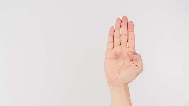 Señal de ayuda. Palma a la cámara y pliegue el pulgar signo de mano sobre fondo blanco.