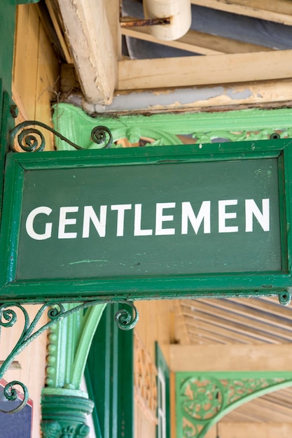 Foto señal de baño de caballero verde en la estación