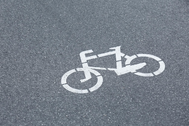 Señal de bicicleta en el pavimento de asfalto gris vista cercana