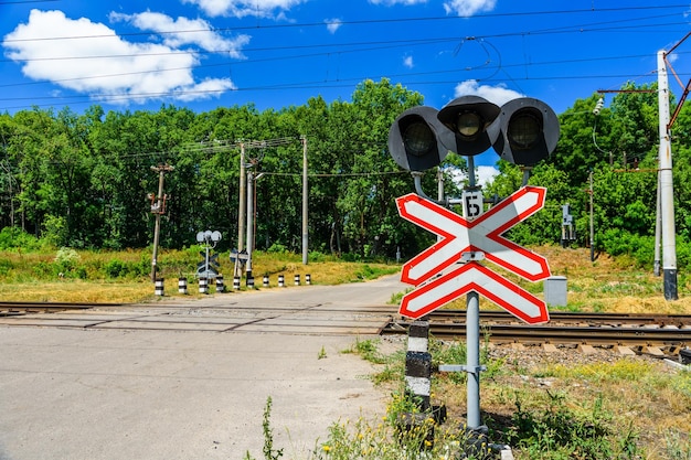 Foto señal de cruce de ferrocarril y semáforo frente al cruce de ferrocarril