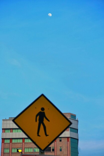 Foto señal de cruce de peatones contra el cielo azul