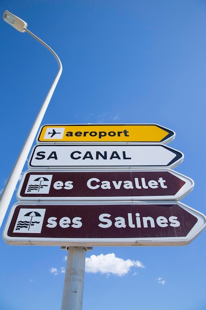 Foto señal de dirección de las playas de cavallet y salines ibiza españa sobre fondo de cielo azul