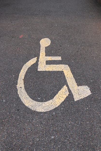 Foto señal de estacionamiento para discapacitados en el asfalto. foto vertical