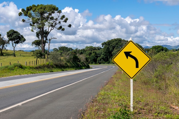 Señal de giro a la izquierda en la carretera con un hermoso paisaje