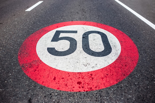 Señal de límite de velocidad de 50 km / h pintada en carretera asfaltada.