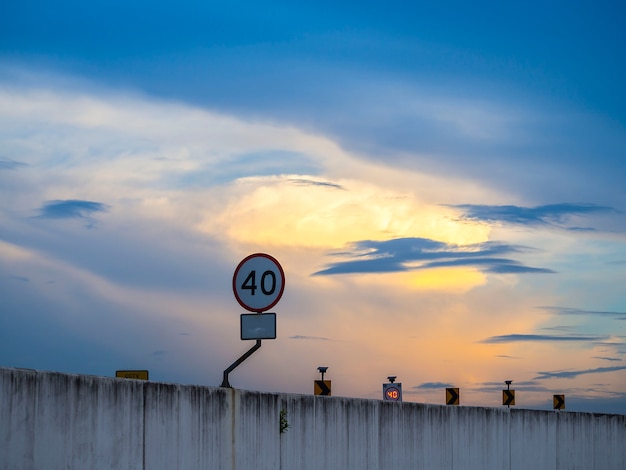 Foto señal de límite de velocidad no exceda los 40 km / h en el puente bajo cielo dramático