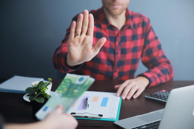 Señal de parada de mano de hombre de negocios en dinero