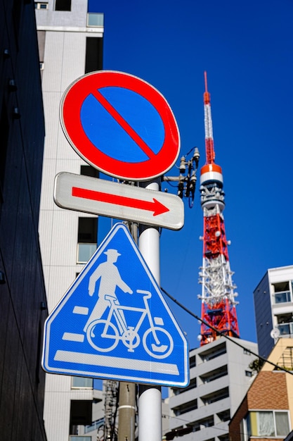 La señal prohíbe que el coche conduzca en la señal de dirección y la señal de correa de bicicleta con la torre de Tokio