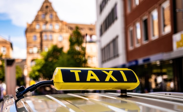 Señal de taxi amarillo en el casco histórico de Alemania tablero de servicio de taxi de primer plano en coche en europ antiguo