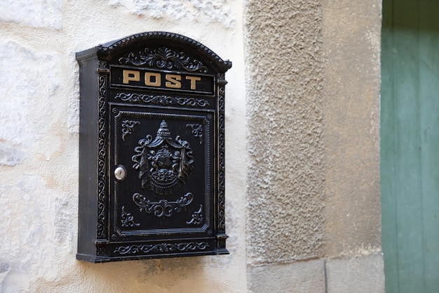 Señal de texto de correo postal en el antiguo buzón privado negro de la calle de la fachada de la casa vintage