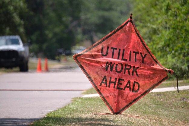 Señal de trabajo en la carretera por delante en el sitio de la calle como advertencia a los automóviles sobre obras de construcción y servicios públicos