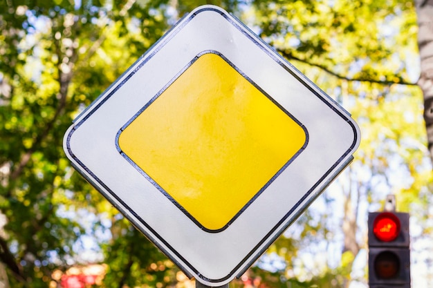 Señal de tráfico carretera principal enfoque selectivo cuadrado amarillo con bordes blancos en el borde de la carretera