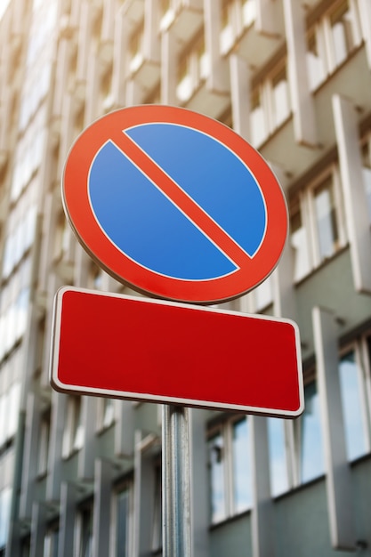 Señal de tráfico "No Parking" en edificio moderno. Dos pizarra en blanco - lugar para el texto.