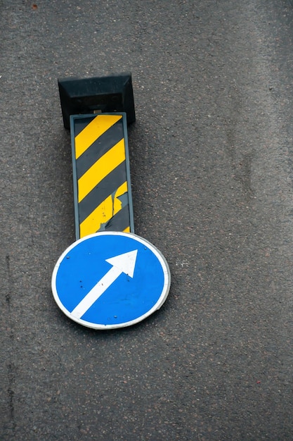 Una señal de tráfico que indica la necesidad de eludir un obstáculo desde el lado derecho se encuentra en la calzada frente a un tramo peligroso de la carretera Reparación de la calzada